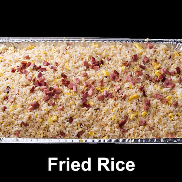 A large aluminum tray filled with fried rice, scrambled eggs, and diced ham.