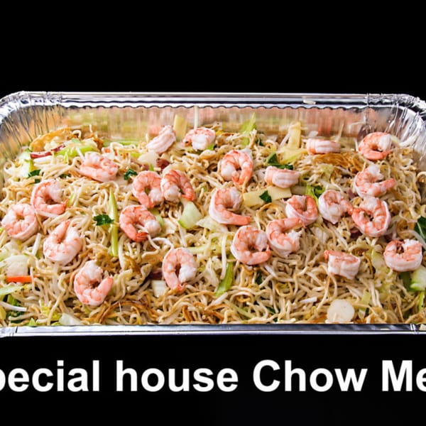 A large aluminum tray filled with shrimp chow mein, featuring noodles, vegetables, and many shrimp.