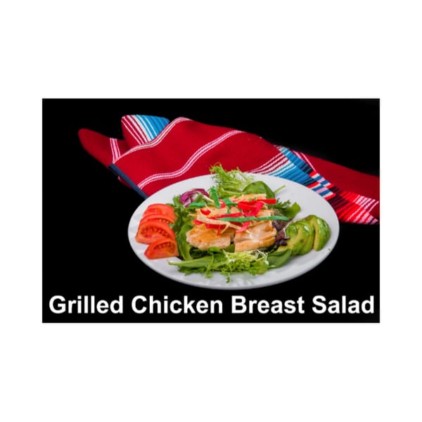 Grilled chicken breast salad with tomatoes, avocado, and colorful tortilla strips on a white plate.