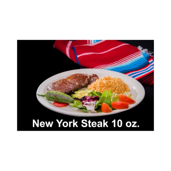 New York Steak with rice, salad, avocado, and a green chili on a white plate.