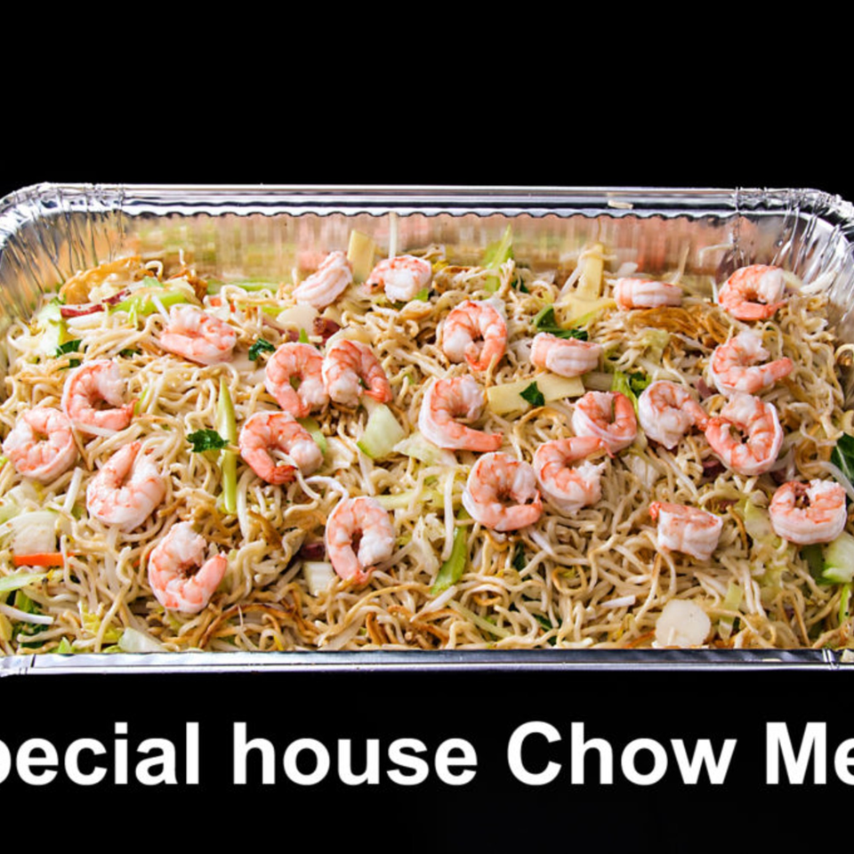 Shrimp chow mein with noodles, vegetables, and shrimp in a foil take-out container.